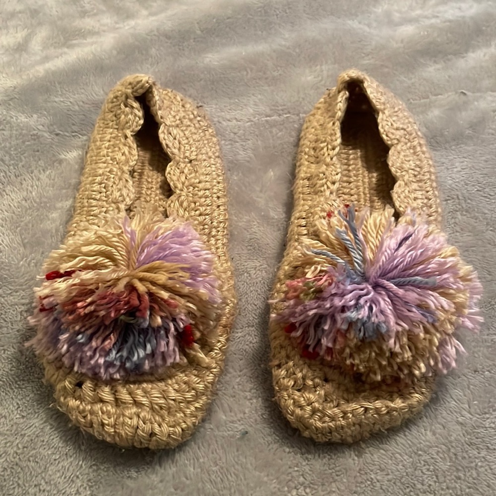Tan colored hand knitted slippers with multicolored pom-poms. Good condition.
